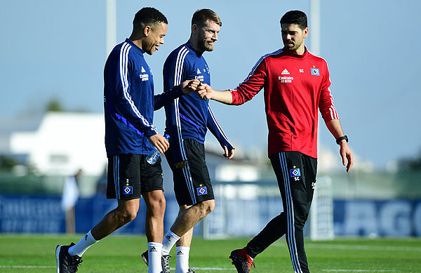 Reha-Trainer Sebastian Capel klatscht mit Jan Gyamerah ab. Daneben geht Aaron Hunt.