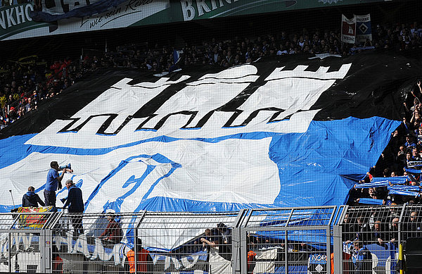 Auch in der Fremde eine Macht: Beim Gastspiel in Dortmund reisten 8.000 HSV-Fans mit. HSV-Fans zeigen großes Transparent mit Hamburg-Wappen.
