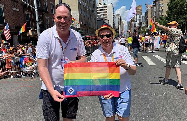 Heiko Jensen und Nicole Schaening zeigen eine Regenbogen-Flagge in New York.