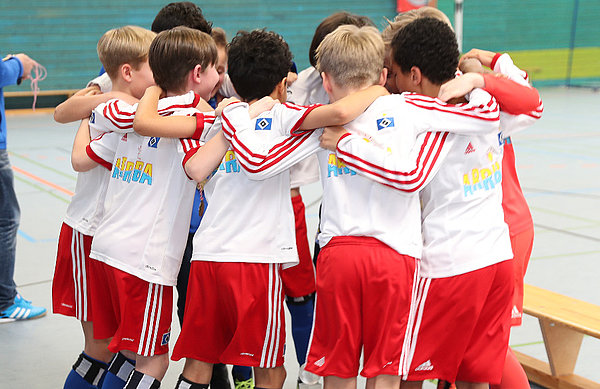 Die Spieler der U11 liegen sich in einem Kreis in den Armen und bejubeln ihren Pokalerfolg.