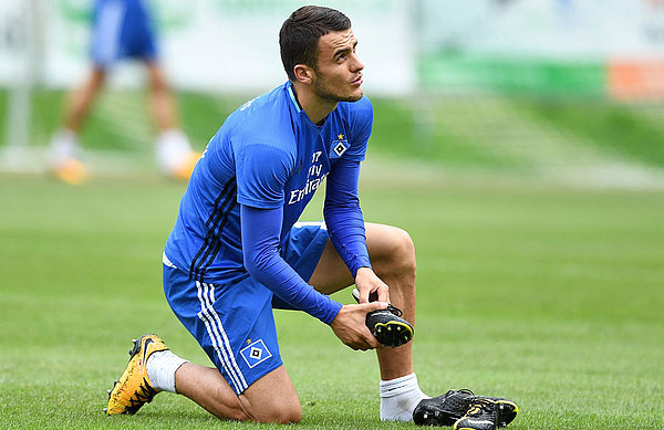 Filip Kostic schnürt sich auf dem rasen die Schuhe.