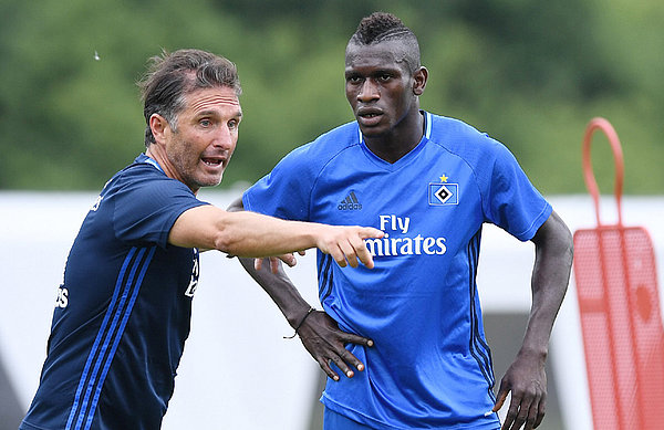 Viele neue Eindrücke auch außerhalb des Platzes. Der Trainer wird weiter behutsam mit Bakery Jatta umgehen. Bruno Labbadia zeigt Bakery Jatta, wie er sich auf dem Platz bewegen soll.