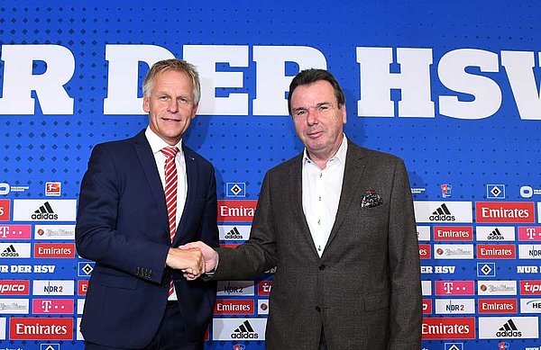 Heribert Bruchhagen und Jens Meier schütteln sich auf dem Podium die Hand. 