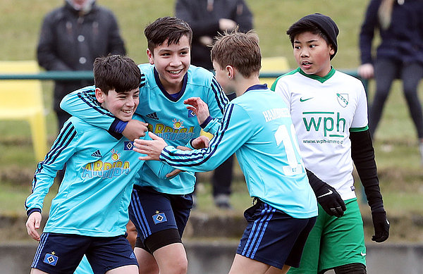 Drei Spieler der U12 vom Hamburger SV freuen sich gemeinsam über ein geschossenes Tor. 