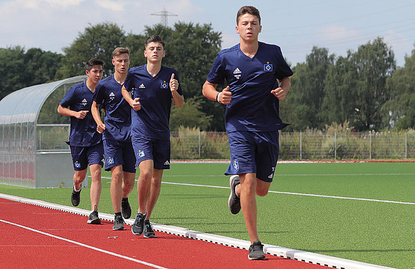 Vier HSV-U16-Spieler laufen auf einer roten Kunststoffbahn ihre Runden.
