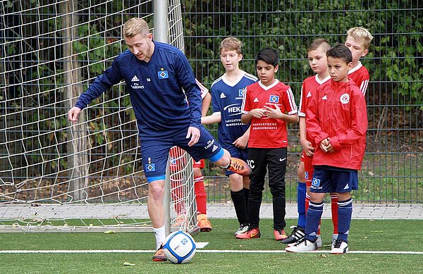 HSV-Mittelfeld-Stratege Lewis Holtby zeigt den jungen Nachwuchs-Fußballern, wie es geht.