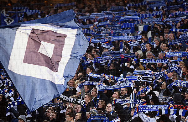 Die Fans auf der Nordtribüne schwenken Fahnen.