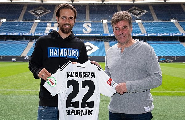 Dieter Hecking und Martin Harnik halten ein HSV-Trikot mit der Aufschrift "Harnik" hoch.