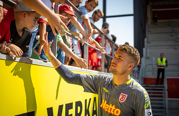 Beim SSV Jahn Regensburg fasste Nordlicht Alexander Meyer sofort Fuß und etablierte sich als Stammkeeper. Bis dato absolvierte er alle acht Pflichtspiele der Saison 2019/20 über die volle Distanz. Alexander Meyer klatscht mit Fans ab.