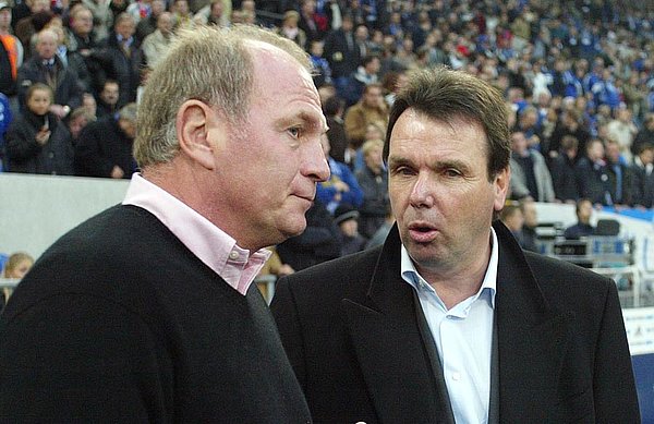 Heribert Bruchhagen und Uli Hoeneß stehen zusammen am Spielfeldrand.